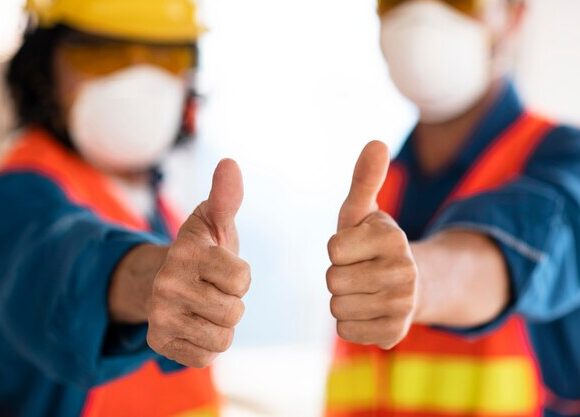 colleagues-with-safety-equipment-showing-ok-sign_23-2148908426